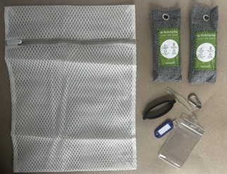Active Family Kit contents laid out on a table: mesh bag, charcoal odor bags, bottle sling, carabiner, and ID tags